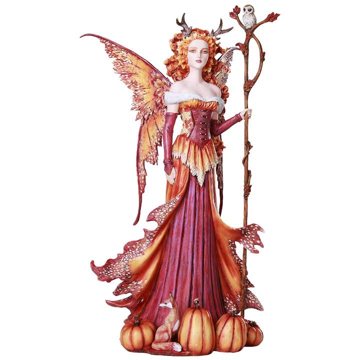 Fantasy fairy figurine with orange hair, wings, and a staff on a white background