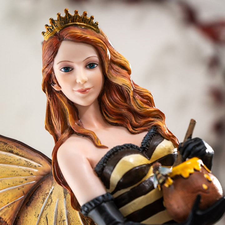 Statue of a fairy-like figure with red hair, butterfly wings, and a crown.