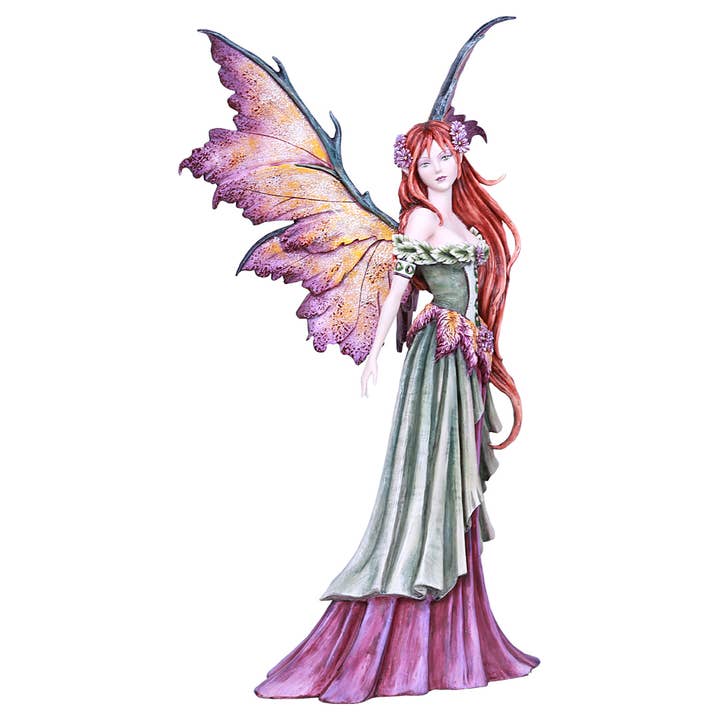 Fantasy fairy figurine with colorful wings and a long dress on a white background