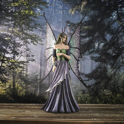 Fantasy fairy figure with butterfly wings standing in a forest setting