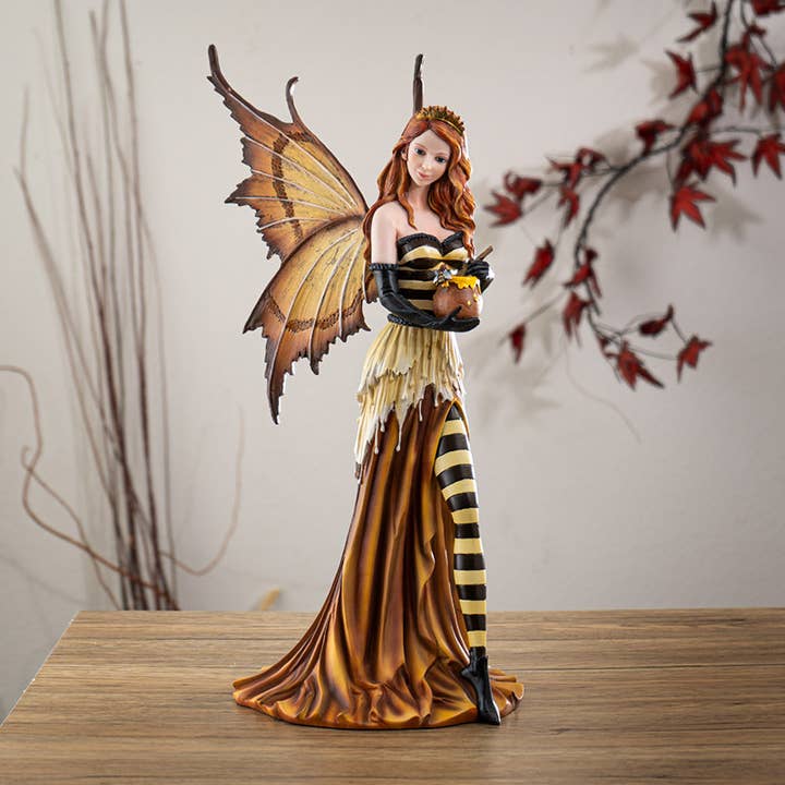 Decorative figurine of a fairy with butterfly wings on a wooden surface.