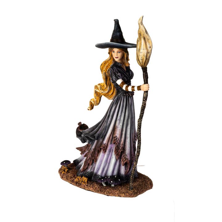 Witch figurine with a broom on a white background