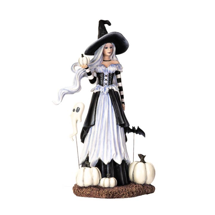 Halloween witch figurine with black hat, white dress, and pumpkins on a white background