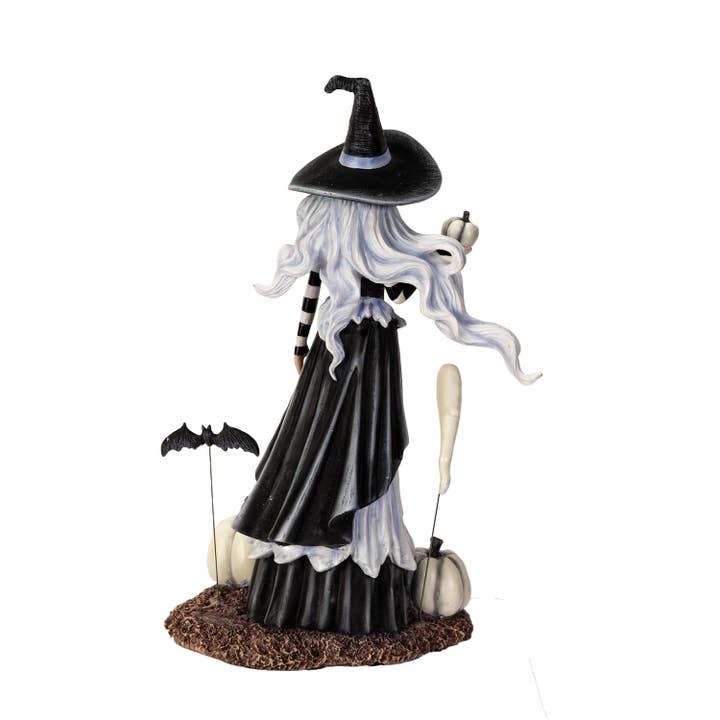 Halloween-themed figurine of a witch with black hat, long white hair, and black dress on a white background.