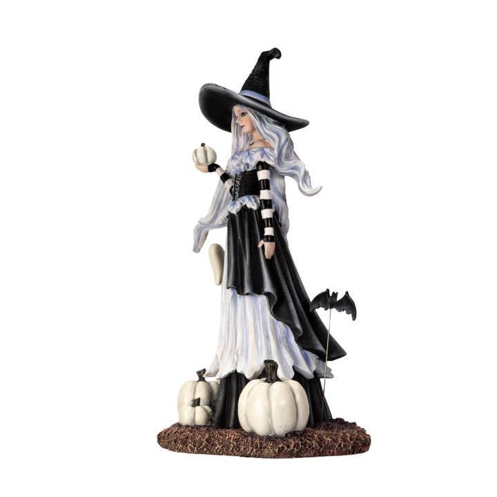 Halloween witch figurine with black hat, long white hair, and black and white striped dress on a white background.