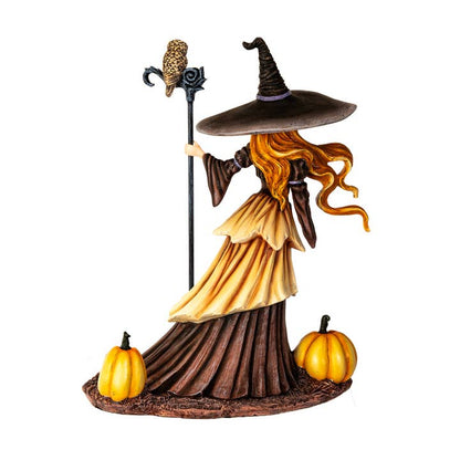 Halloween-themed figurine of a witch with pumpkins on a white background