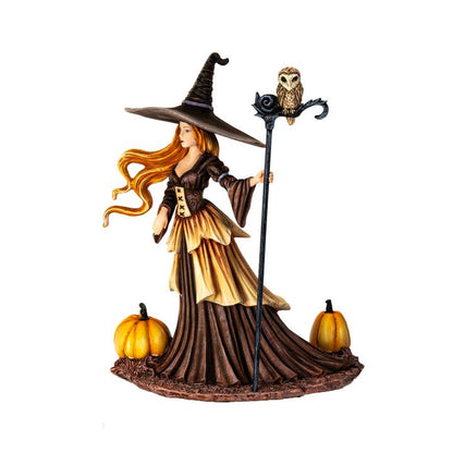 Halloween-themed figurine of a witch with an owl and pumpkins on a white background
