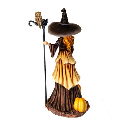 Halloween-themed figurine of a witch with a broom, owl, and pumpkin on a white background