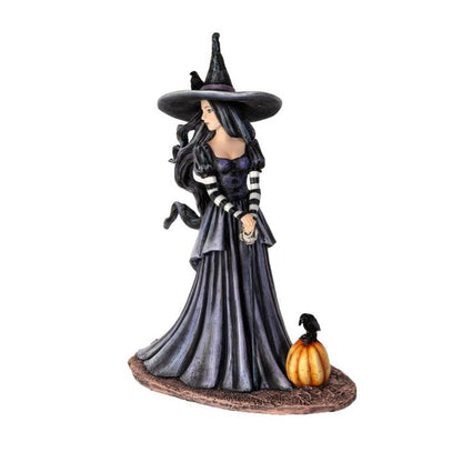 Witch figurine with a pumpkin on a white background