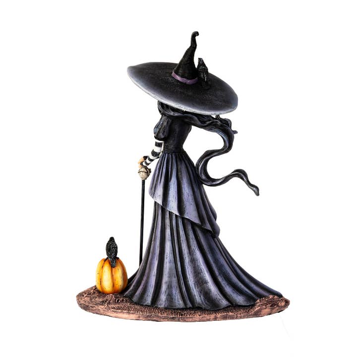 Halloween witch figurine with a pumpkin on a white background