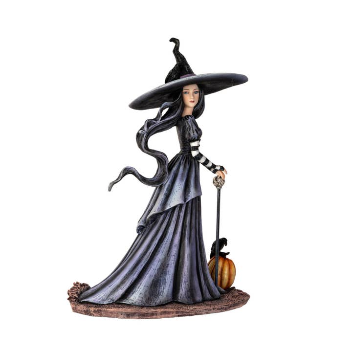 Statue of a witch with long hair, black hat, and pumpkin on a white background