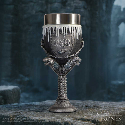 Decorative goblet with 'Winter is Coming' text and 'Stark' emblem on a stone surface with a dark, forest-like background.