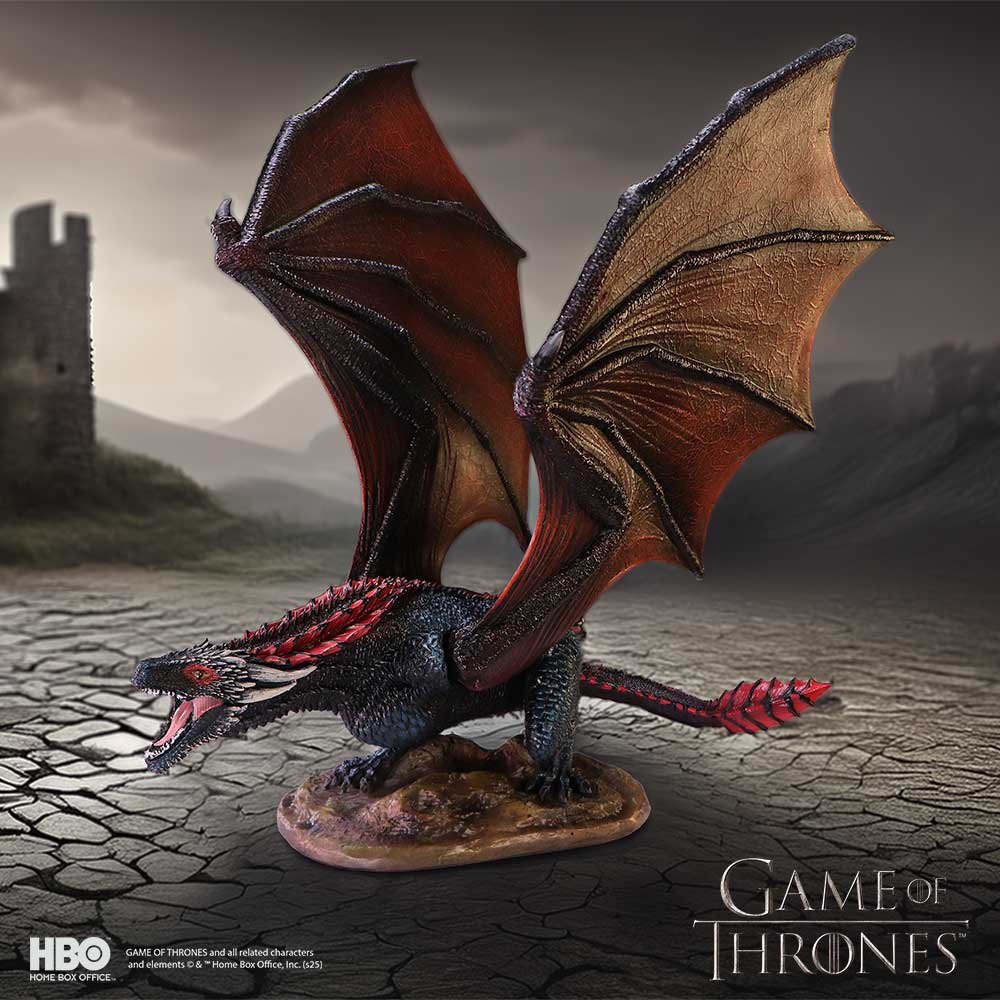 Dragon figurine from 'Game of Thrones' with cracked ground and castle in the background