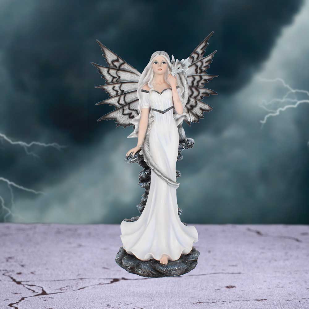 Statue of a fairy with white wings and dress against a stormy background
