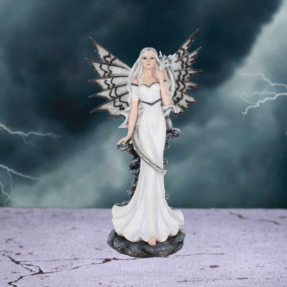 Statue of a fairy with white wings and dress against a stormy background